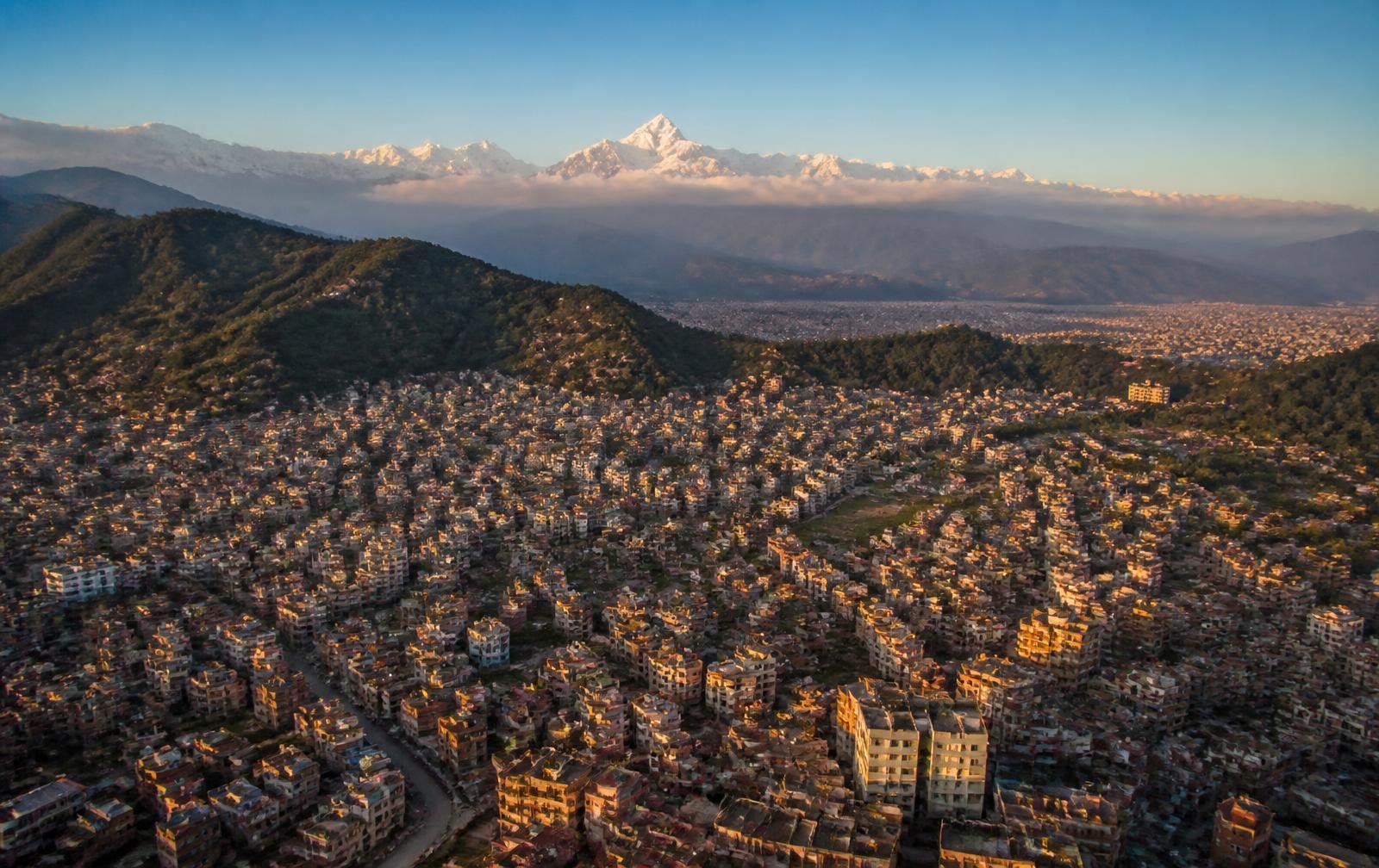 The Kathmandu valley at golden hour with the Himalaya behind it